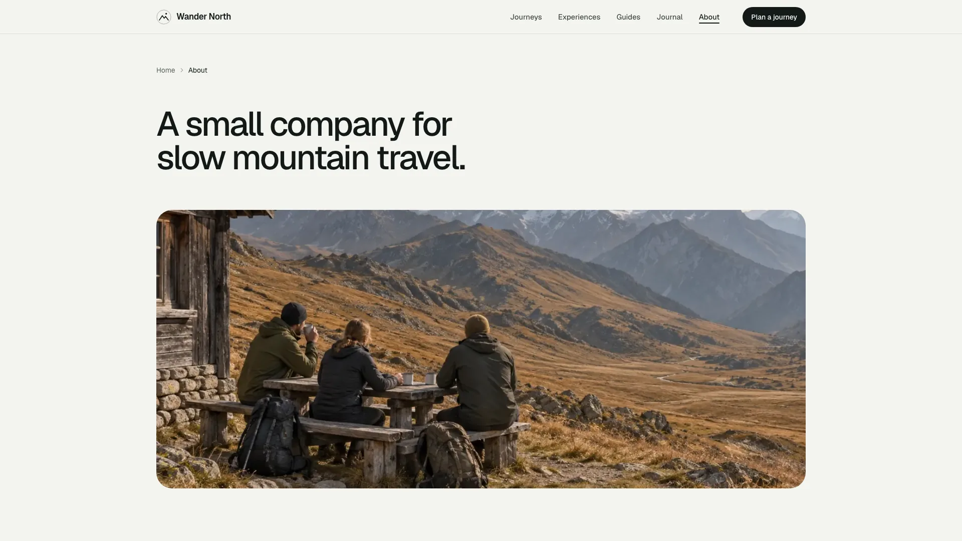 About page with the headline A small company for slow mountain travel above a photo of walkers at a hut table